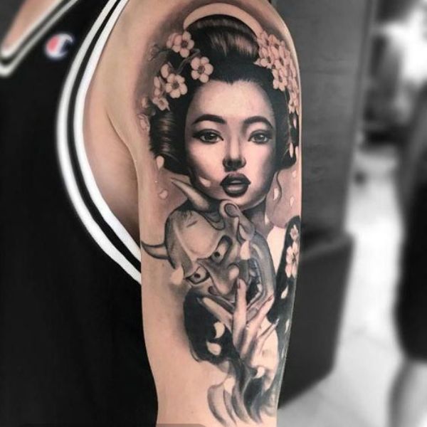Tattoo cô gái đeo mặt quỷ ở bắp tay