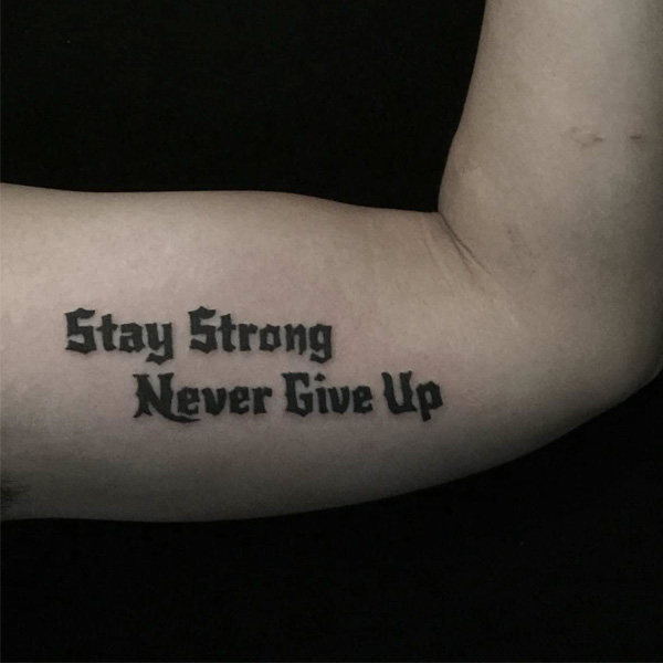 Hình xăm chữ Never Give Up ở bắp tay