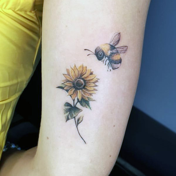 Hình xăm hoa và ong ở cánh tay